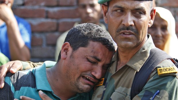 An Indian army soldier tries to console a relative of his colleague Randeep Singh, who was killed in Thursday's rebel attack in north-eastern Manipur state, India.