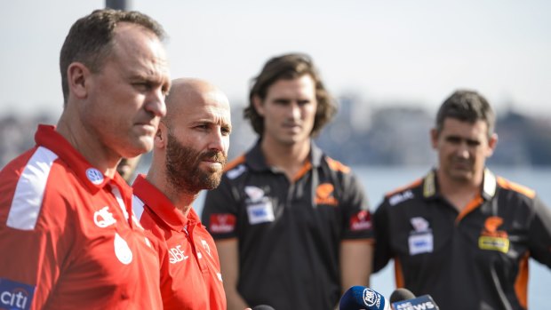 "Once the ball bounces any of those talks fall out the window straight away. Both sides are really evenly matched": John Longmire, with Swans' skipper Jarrad McVeigh, and GWS counterparts Callan Ward and Leon Cameron. 