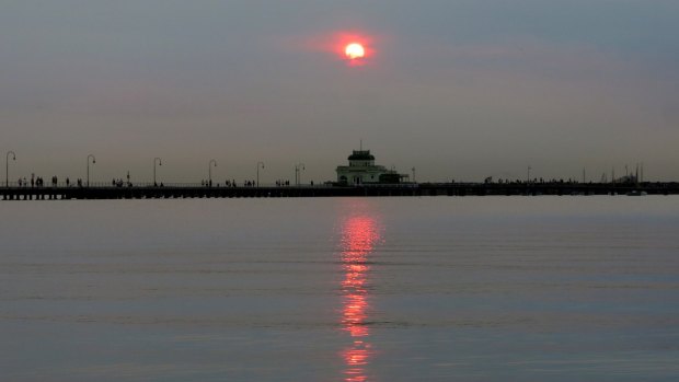 A blood red sun sets over St Kilda Pier on Wednesday night due to smoke haze from the WA fires.