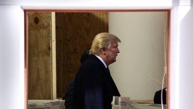 Donald Trump walks through construction works in the lobby of the Old Post Office building in Washington, now being developed into a Trump International Hotel.