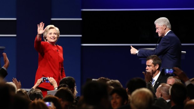 Hillary Clinton, 2016 Democratic presidential nominee, left, waves as former US president Bill Clinton gestures during the first presidential debate.