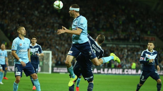 Up and at them: Sydney FC defender Matt Jurman heads the ball away from Besart Berisha of the Victory during the  A-League grand final at AAMI Park on Sunday.