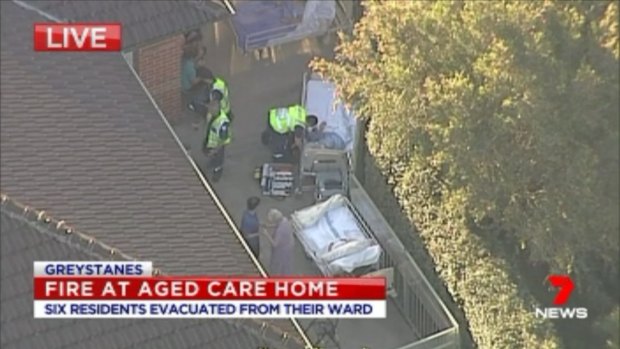 Paramedics treat residents at the aged care home in Greystanes.