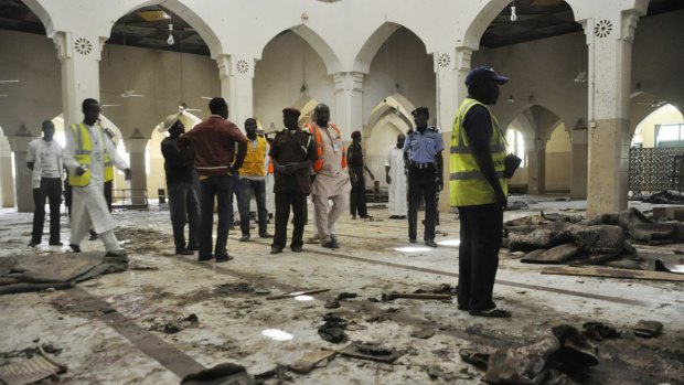 People inspect the central mosque following a bomb explosion in Kano, Nigeria on November 29. 