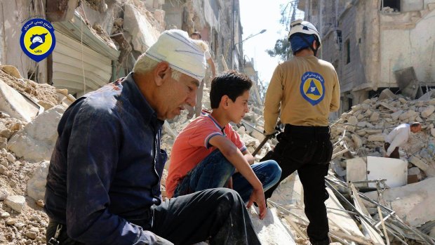 Residents sit among rubble in rebel-held eastern Aleppo, Syria last month.