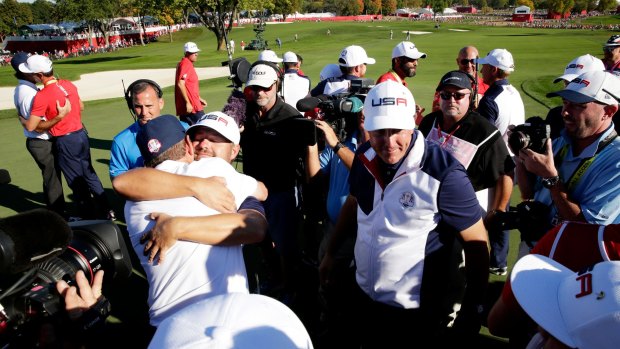 Winners: US captain Davis Love celebrates with Ryan Moore and Phil Mickelson on the 18th green.