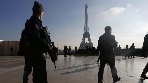 On high alert: French police officers patrolling near the Eiffel Tower after the Paris attacks.