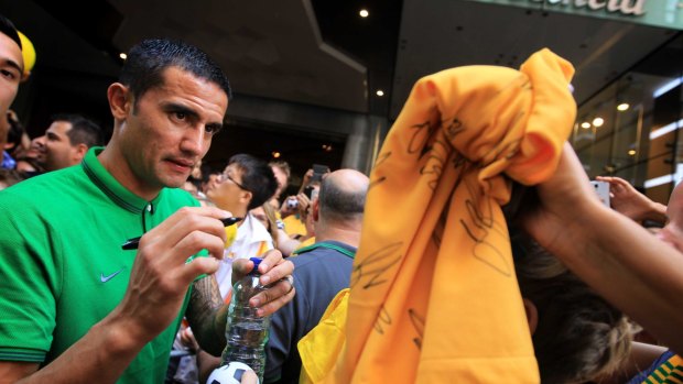 Sign of the times: "Talisman" Tim Cahill autographs Socceroos merchandise. 