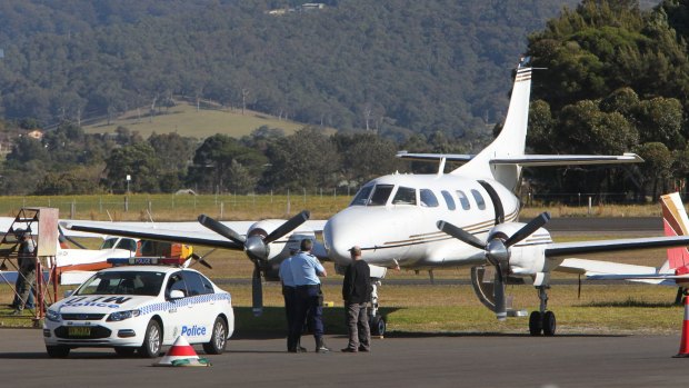 Police examine the twin-engine turbo-prop Swearingen Merlin 3 eight-seater at Illawarra Regional Airport on July 9, 2014. 