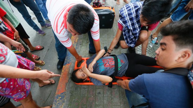 A protester who was run over by a Philippine National Police van waits for treatment outside the US embassy in Manila on Wednesday.