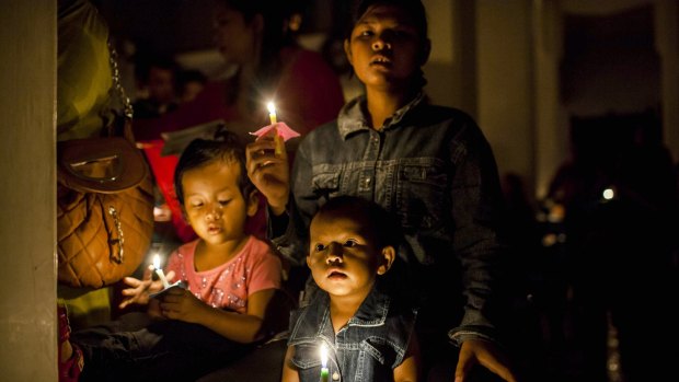 Christian worshipers hold candles as they attend a mass in Aceh, Indonesia.