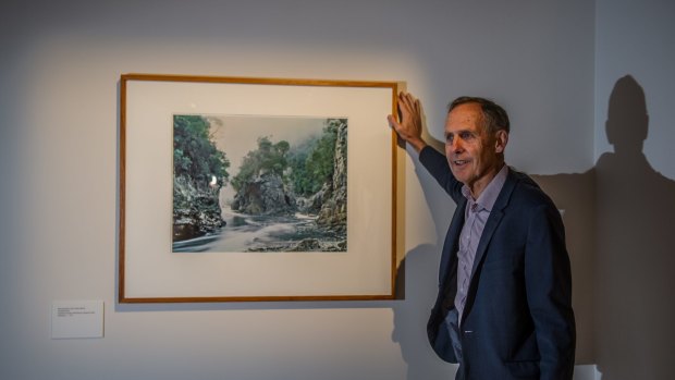 Former Greens leader Bob Brown poses with the Peter Dombrovskis photograph that was instrumental in saving the Franklin River. 