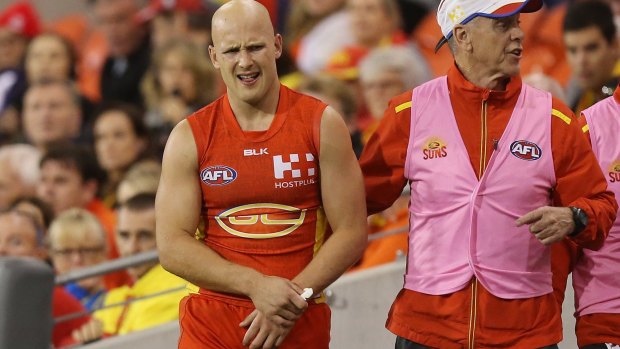Gold Coast star Gary Ablett leaves the field with a shoulder injury.