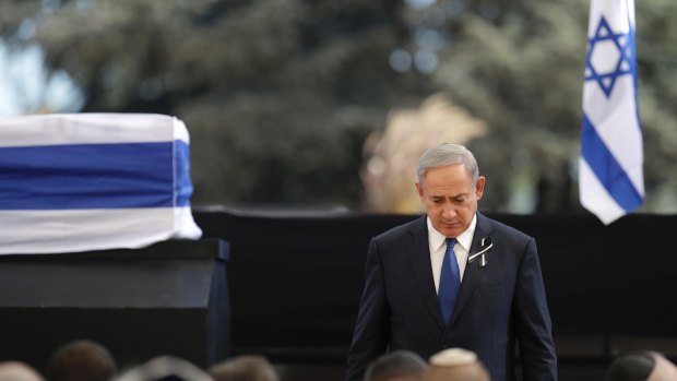 Israeli Prime Minister Benjamin Netanyahu walks from the stage past the casket of former Israeli president Shimon Peres.