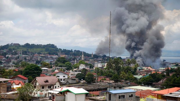 Smoke rises from houses following airstrikes by Philippine Air Force bombers as government forces battle to retake control of Marawi.