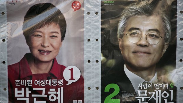 Posters of South Korean presidential candidates Park Geun-hye, left, and Moon Jae-in before the 2012 election won by Ms Park.