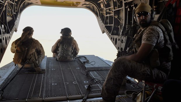 Emirati soldiers stand guard out the rear gate of a Chinook military helicopter en route  from Saudi Arabia to Yemen on Monday. 