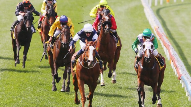 Record-breaking win:  Hugh Bowman (centre in white cap) rides The United States to victory in the Moonee Valley Cup.  