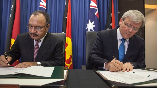 Papua New Guinea's Prime Minister Peter O'Neill and Kevin Rudd sign an agreement over asylum seekers in July 2013.