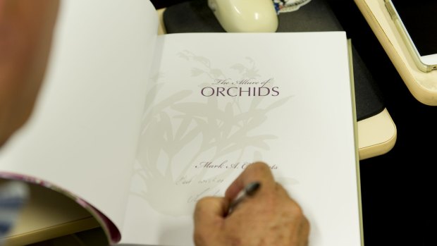 Dr Clements signs a copy of his book, The Allure of Orchids.