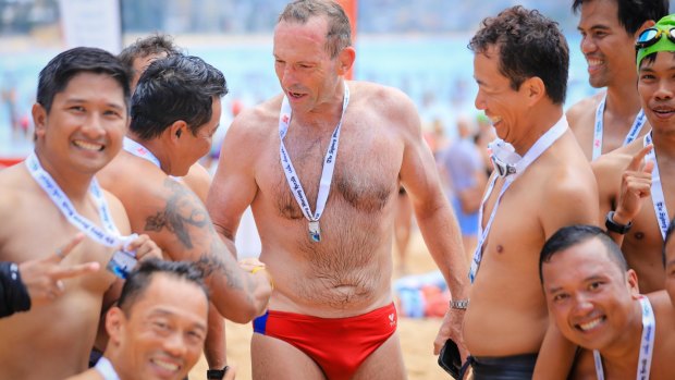 Former PM Tony Abbott is congratulated after finishing the 2km swim in the Sydney Morning Herald Cole Classic at Manly in February.