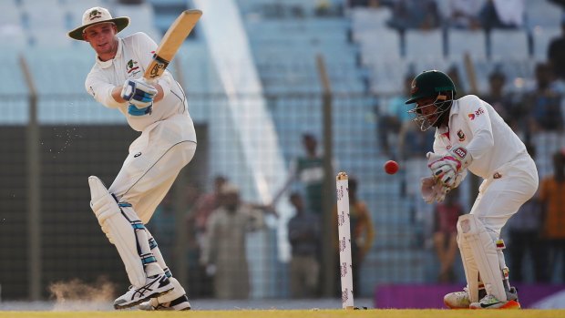 Australia's Peter Handscomb plays a shot as Bangladesh's wicketkeeper captain Mushfiqur Rahim follows the ball.
