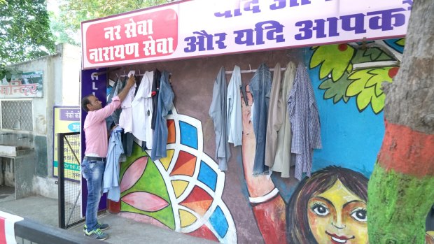 A man inspects a shirt at the wall in Bhilwara.