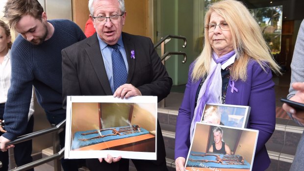 Mark and Faye Leveson hold photos of the skeletal remains of their son Matthew Leveson after giving their impact statement at the Coroner's Court  on Friday.
