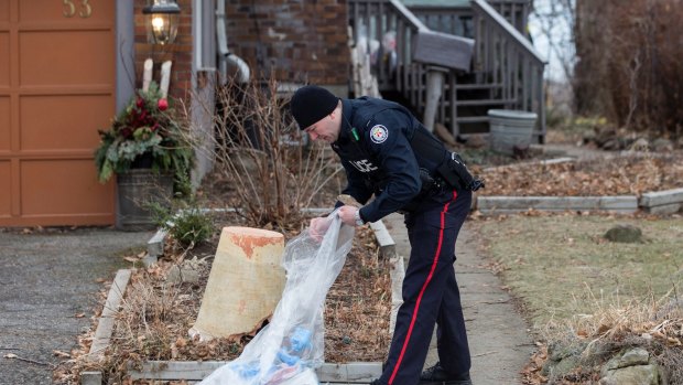 A police officer investigates outside a house on Mallory Crescent in Toronto, where Bruce McArthur did landscape work.