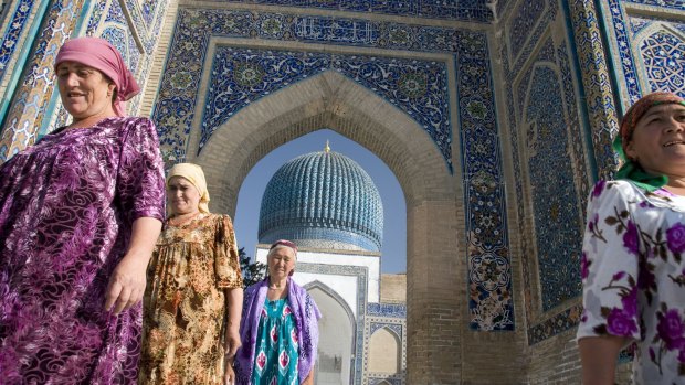 Women in traditional dress leave after paying homage at the Guri Amir, Timur's Mausoleum, in Samarkand, Uzbekistan.