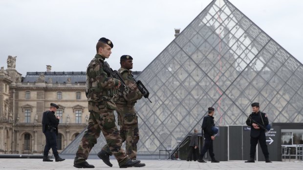 French military patrol the Louvre in Paris, which reopened on Monday.