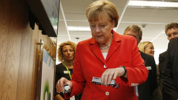 Ms Merkel with model trucks at the research facility.