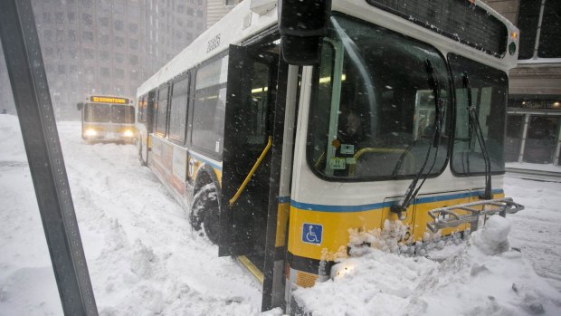 Snowed in: A bus becomes stuck in a snowbank in Boston.