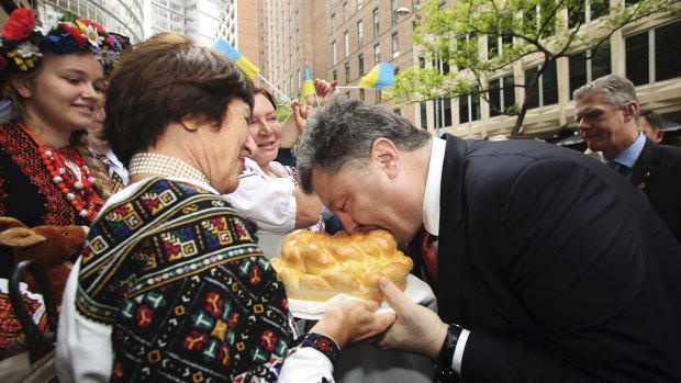 Kristina Bailey presents a bread dish to Ukrainian President Petro Poroshenko  at the Lowy Institute in Sydney. 
