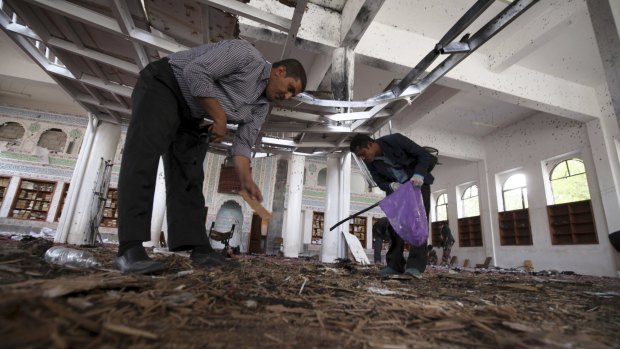 Crime scene investigators search for evidence on the floor after a suicide bomb attack at a mosque in Sanaa.