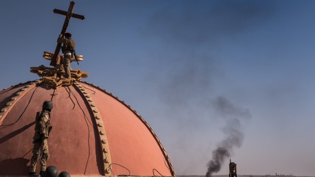 November 2016: Kurdish fighters replace the cross on the dome of the Immaculate Cathedral in Qaraqosh, Iraq, after taking the town back from Islamic State. But how would Christian minorities fare in a Kurdish state?