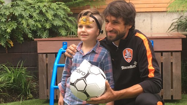 Ole Walton, who was born with microtia, with Brisbane Roar's Thomas Broich at the Hear and Say Centre.