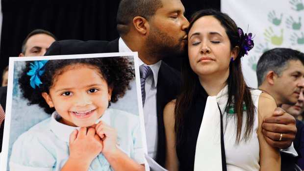 Jimmy Greene kisses his wife Nelba Marquez-Greene while holding a portrait of their slain daughter Ana Marquez-Greene.