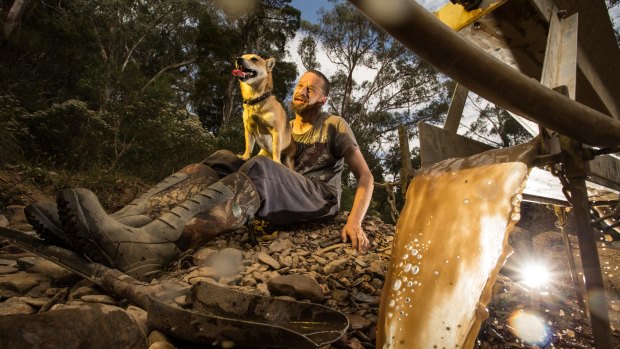 Glenn Mueller is mining for gold in the dry bed of the Lerderderg River near Blackwood in the Macedon Ranges. Pictured here with his dog Rastus. 