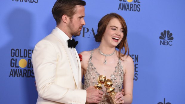 Ryan Gosling and Emma Stone with their Golden Globe awards for their performances in <i>La La Land</i>.