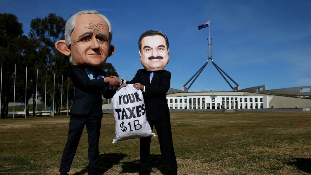 Protestors wearing suits resembling Prime Minister Malcolm Turnbull and Adani chief, Gautam Adani, take part in a protest in Canberra on Thursday.