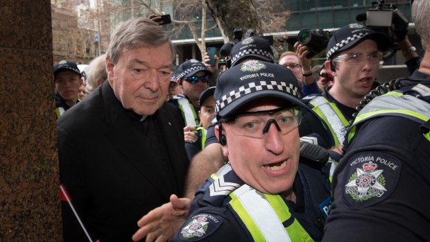 The cardinal leaves court, surrounded by police and a media pack.