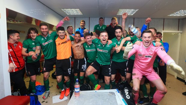 History made: The Lincoln City team celebrate their win against Burnley.
