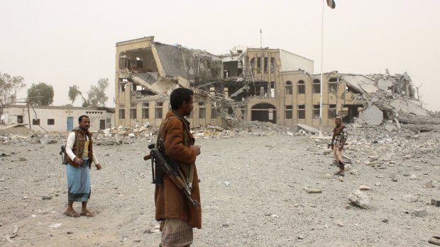 Police stand near their headquarters, destroyed by Saudi-led air strikes, in Yemen's north-western city of Saada.