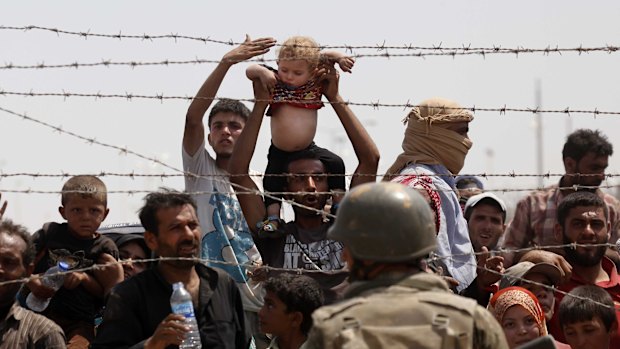 Syrian refugees passing on the Syrian side of the border crossing at Akcakale earlier this year.