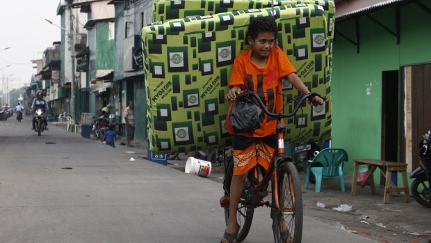 Testing times - Kelvin, a Kalijodo resident, helps his family move.