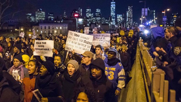 The Lower Manhattan skyline, including One World Trade Centre, is seen in the background as protesters, demanding justice for Eric Garner, enter Brooklyn off the Brooklyn Bridge in New York.