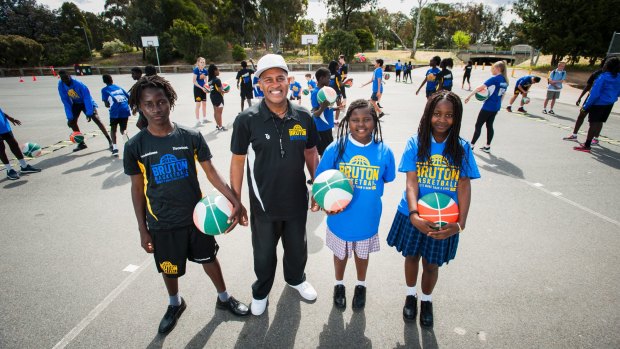 Former basketball player Cal Bruton with refugee children Clarence,15, Clarice, 10, and Christabel Machiridza, 16 at St Francis Xavier College.
