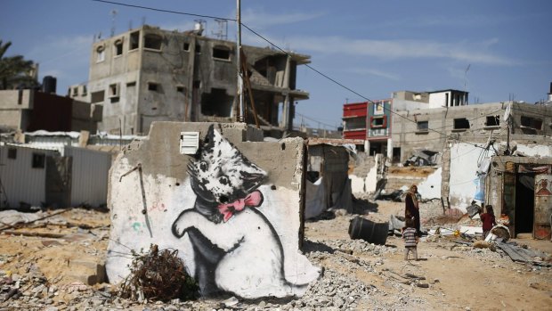 A mural of a playful-looking kitten, thought to have been painted by British street artist Banksy, is seen on the remains of a house that witnesses said was destroyed by Israeli shelling last summer.