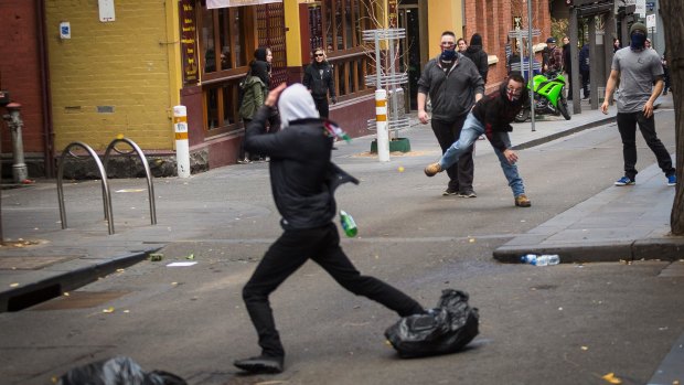 Members of the United Patriot Front throwing a bottle at a counter-protester.